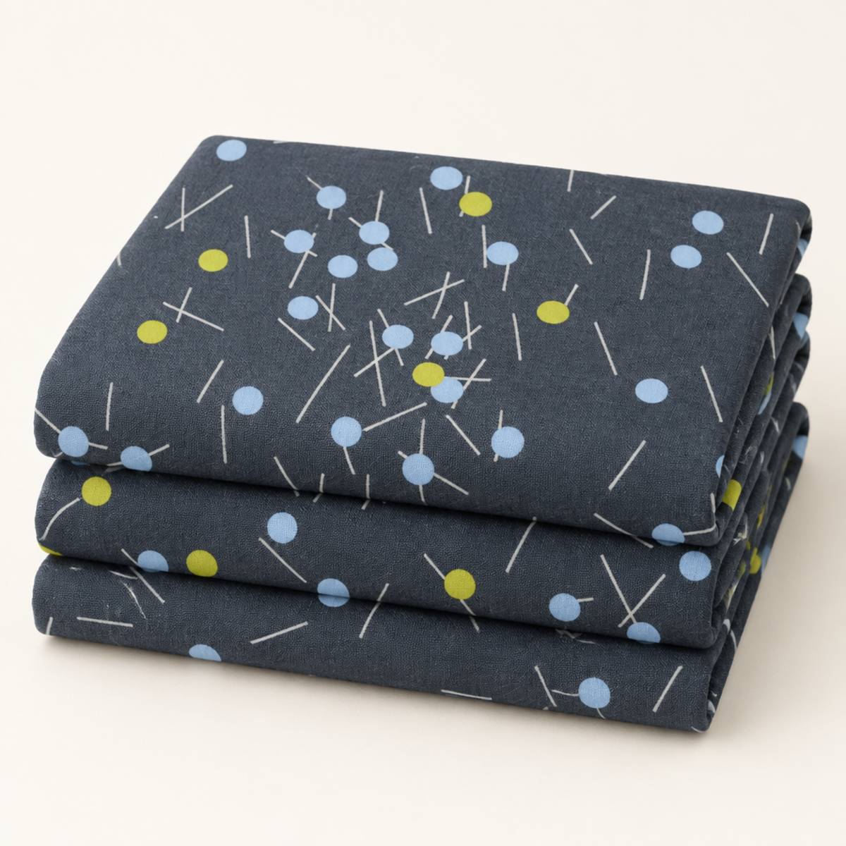 Neatly folded Bluish Pins & Buttons Charcoal quilting cotton by Zen Chic, featuring pale blue and chartreuse button-head pins.