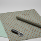 The Fox Homestead Slate Blue Green Tossed Cubes quilting cotton fabric styled in a modern quilting studio with a cutting mat and rotary cutter.