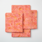 Expressions Batiks Hand-Dyes Sunset quilting cotton fabric by Riley Blake Designs folded into a neat square showing soft coral-pink hand-dyed batik with warm golden-orange splashes, soft peach tones, and hints of deeper rose – a luminous warm focal blender, 100% cotton batik, 43–44" wide