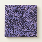 Folded Superbloom Leafy Indigo fabric by Robin Pickens for Moda Fabrics on a light surface, showing lavender-purple leafy branches on dark indigo cotton.