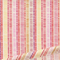 Close-up of Superbloom Scribble Stripe Cream fabric by Robin Pickens for Moda Fabrics, with colorful scribble stripes on cream cotton and a soft diagonal fold along the lower edge.