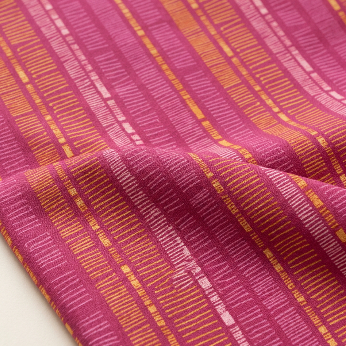Close-up of Superbloom Scribble Stripe Orchid fabric by Robin Pickens for Moda Fabrics, showing golden-orange and pink scribble stripes across softly folded orchid-magenta cotton.