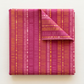 Folded Superbloom Scribble Stripe Orchid fabric by Robin Pickens for Moda Fabrics, with a turned-back corner showing golden-orange and pink stripe bands on orchid-magenta cotton.