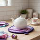Leaf-Shaped Quilted Hot Pad – Lavender Garden under a white teapot | IraRobi Quilts #quiltedhome #hotpad #handmadegift