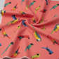 Close-up of coral sorbet pink quilting cotton with colorful tropical parrots in soft folds — Safari Fun Jungle Birds Sorbet by Terry Runyan for Benartex