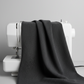 Texture Graphix Speckle Black fabric by Jason Yenter for In The Beginning Fabrics draped over a sewing machine – deep charcoal-black tonal speckled blender quilting cotton, 43–44" wide