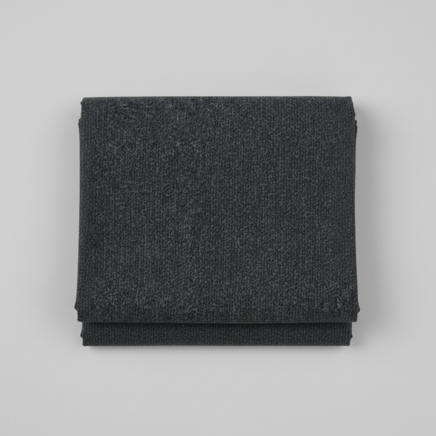 Texture Graphix Speckle Black quilting cotton fabric folded to show texture – tonal charcoal-black speckled blender by Jason Yenter for In The Beginning Fabrics, 100% cotton