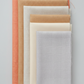 Thatched Basics by Robin Pickens for Moda Fabrics — five coordinating near-solid quilting cottons fanned in coral, shadow, washed linen, cream, and heather colorways, all with subtle crosshatch texture, stacked on light grey background