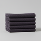 Thatched Shadow deep purple fabric by Robin Pickens for Moda Fabrics – neatly folded stack showing rich color and crosshatch woven texture. Coordinating fabrics and quilt patterns are available at IraRobi Quilts.