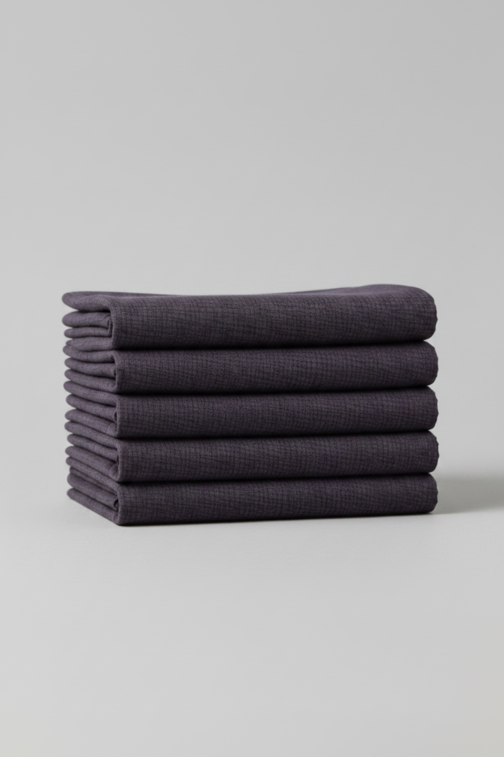 Thatched Shadow deep purple fabric by Robin Pickens for Moda Fabrics – neatly folded stack showing rich color and crosshatch woven texture. Coordinating fabrics and quilt patterns are available at IraRobi Quilts.