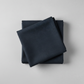 Thatched Soft Black quilting cotton by Robin Pickens for Moda Fabrics — neatly folded in a stack on a light grey background showing the deep navy-black ground with signature crosshatch texture. 100% cotton, 44–45" wide. Available at IraRobi Quilts.