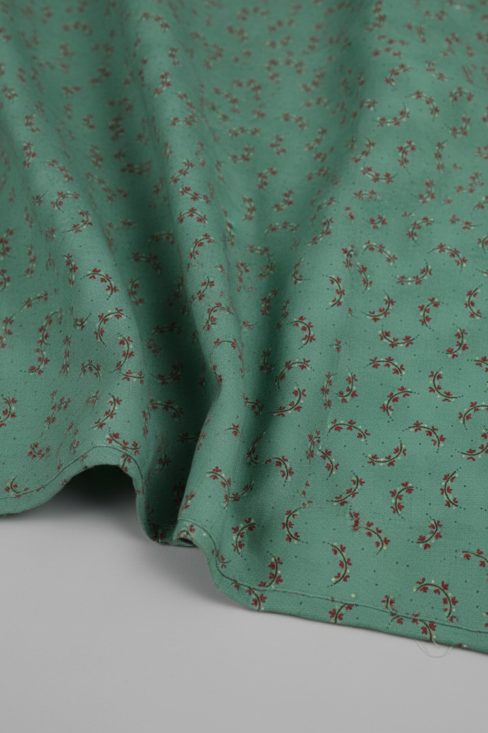 Scraps of Kindness Turquoise Heart Sprays quilting cotton in soft natural folds close-up — turquoise with crescent heart spray print, emphasizing fabric drape and texture, by Kim Diehl for Henry Glass