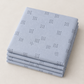 Folded stack of Celestial Nine Triangle Stardust fabric by Zen Chic for Moda Fabrics, with charcoal triangle clusters on pale blue-gray.