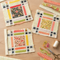 Three unfinished Fringe-inspired quilt blocks on a sewing table with Dandi Duo Cream strips, coordinating scraps, thread, clips, and scissors. The pattern is shown for inspiration and is not included with the fabric.