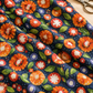 Superbloom Posy Party Indigo fabric by Robin Pickens for Moda Fabrics, draped in soft folds on a wooden table beside scissors and cream thread.