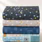 Vertical stack of coordinating modern quilting fabrics in charcoal, gray, navy, and pale blue, topped with Bluish Pins & Buttons Charcoal.