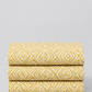 Lazy Afternoon Golden fabric folded in three layers on a light background, showing the repeating golden geometric maze print.