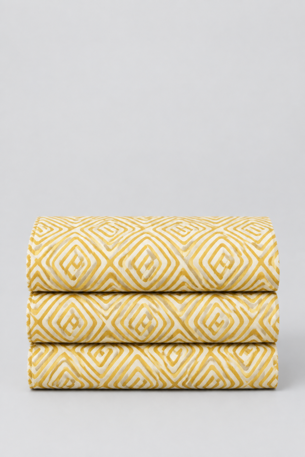 Lazy Afternoon Golden fabric folded in three layers on a light background, showing the repeating golden geometric maze print.