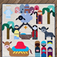 Starry Night handmade nativity quilt laid flat on wooden decking, featuring colorful figures, animals, palm trees, and a gold star.