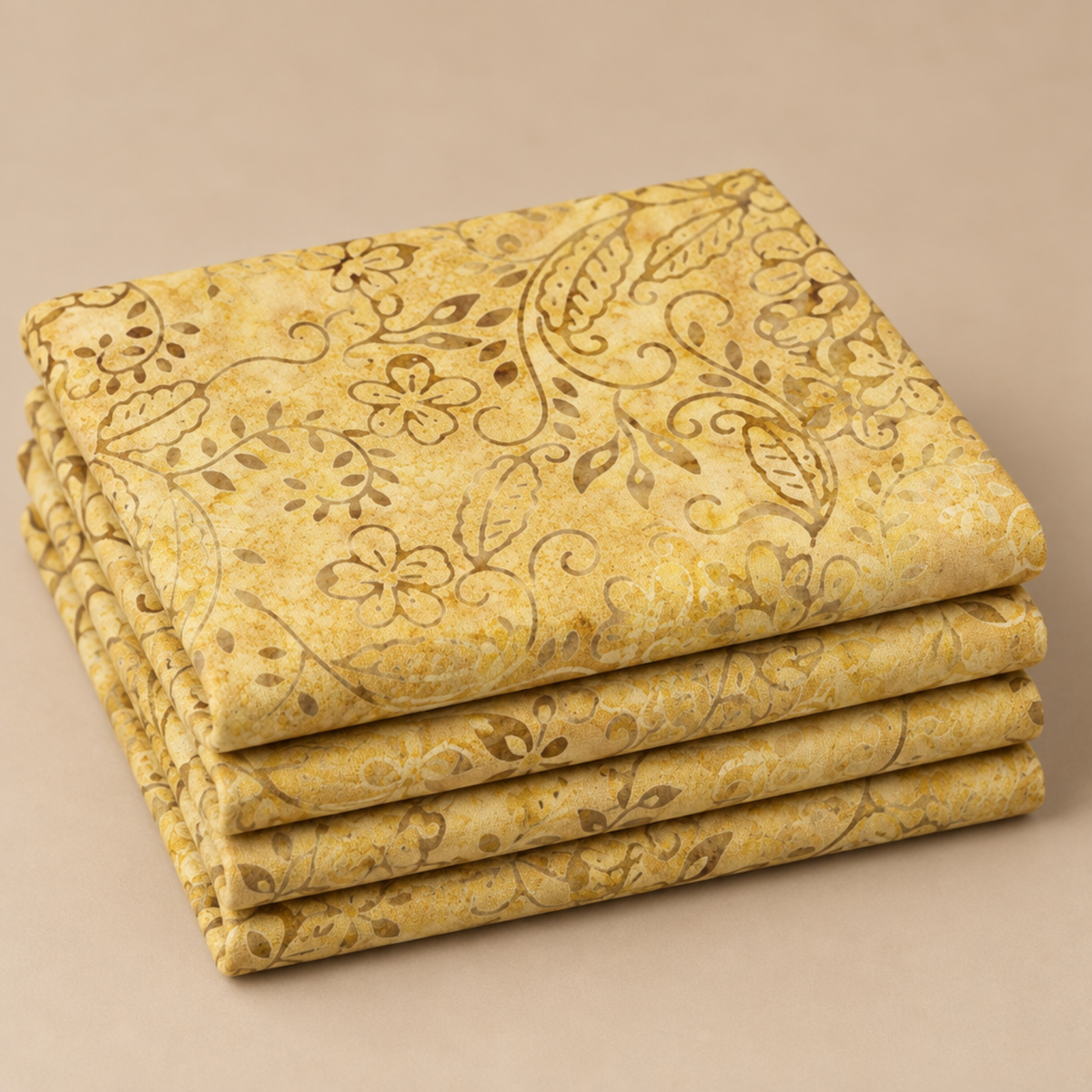 Folded Windsong Tonga Batiks Viney Floral Fawn fabric by Wing and a Prayer Design for Timeless Treasures, featuring cream, honey, tan, and taupe flowers and vines on fawn gold.