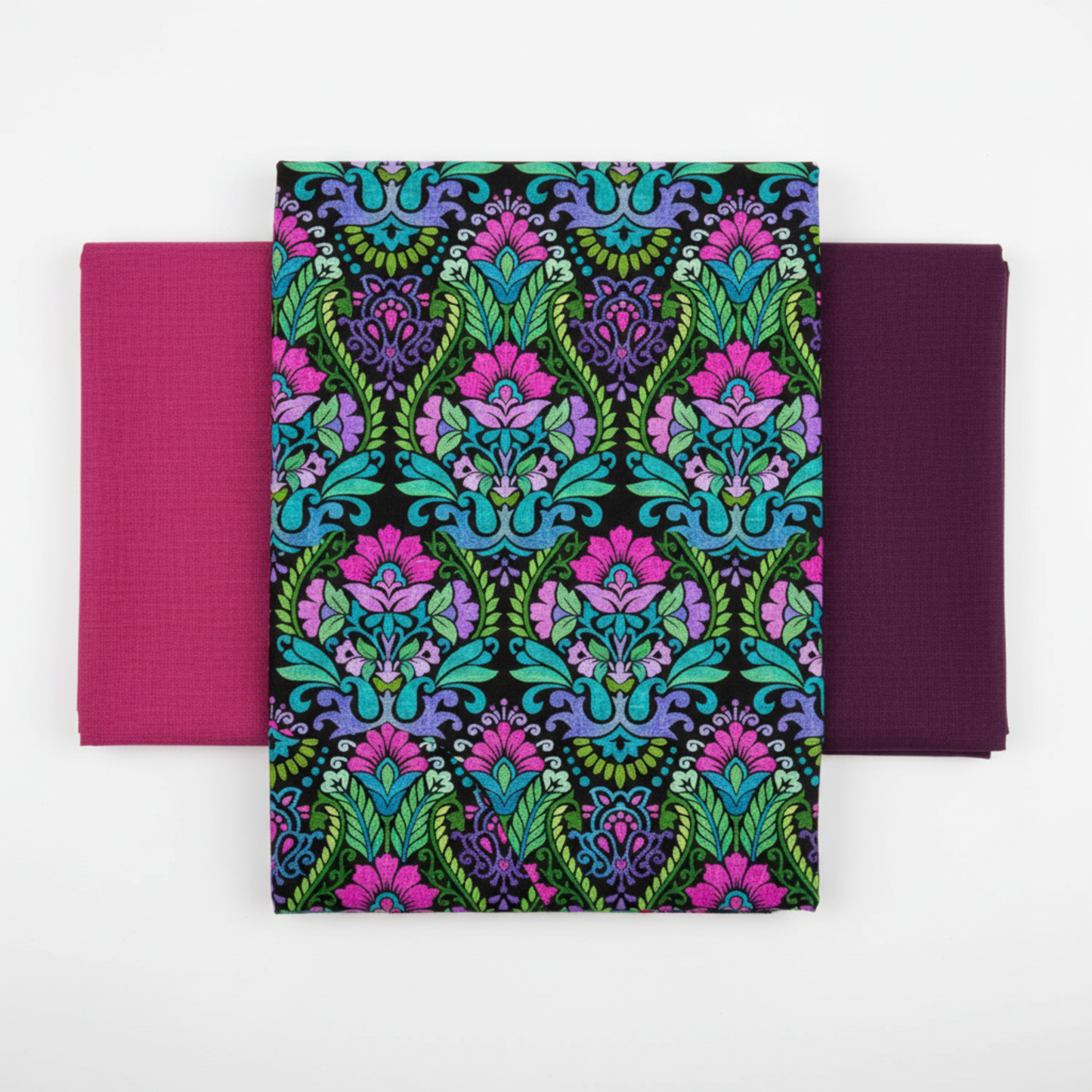Vivid Brocade Jewel quilting cotton fabric by Jason Yenter for In The Beginning Fabrics shown in a coordinate fan with Interwoven Magenta and Interwoven Plum blenders – dramatic allover baroque brocade with magenta and purple damask florals and teal scrolling leaves on deep black, 100% cotton, 3 yard cut