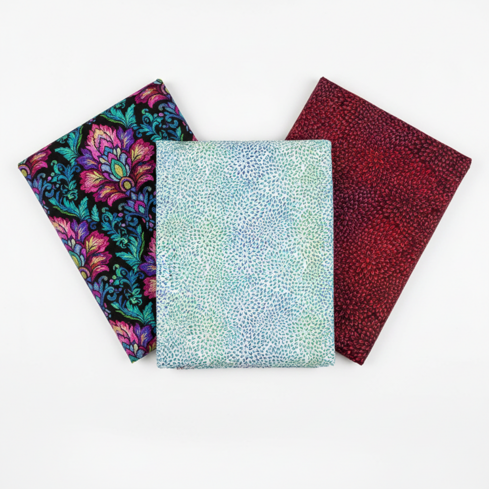 Vivid Mums Jewel Blue quilting cotton fabric by Jason Yenter for In The Beginning Fabrics shown in a coordinate fan with Vivid Brocade Jewel and Vivid Mums Spice Red – luminous chrysanthemum burst blender in periwinkle and teal on pale blue-silver with magenta baroque brocade on black and crimson chrysanthemum burst on dark burgundy, 100% cotton, 3 yard cuts