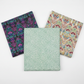 Vivid Mums Spice Teal quilting cotton fabric by Jason Yenter for In The Beginning Fabrics shown in a coordinate fan with Vivid Brocade Jewel and Vivid Brocade Spice – dense chrysanthemum burst blender in teal and emerald on cream-grey with magenta baroque brocade on black and crimson baroque brocade on warm cream, 100% cotton, 3 yard cuts