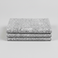 Writing on the Wall Well Worded White quilting cotton in soft fold stack — grey background with white and black word art typography, FreeSpirit Fabrics