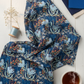 Whimsy Anemones and Berry Pods Blue 3 Yard Cut quilting cotton by Jason Yenter for In The Beginning Fabrics — loosely draped on a linen surface with coordinating navy, cobalt, and cream fabric swatches, light blue thread spool, dried botanicals, and a mug of tea. Coordinating fabrics and quilt patterns are available at IraRobi Quilts.