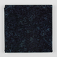 Folded Whispering Hollows Raven batik fabric by Riley Blake Designs, showing dark navy and black damask scrollwork against a light gray background.