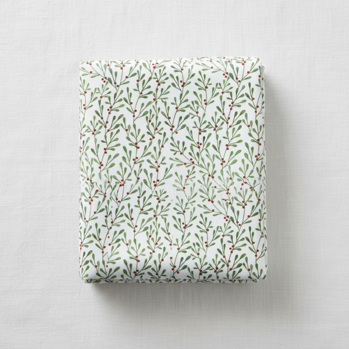 Winter Solstice II White Branches quilting cotton by Jason Yenter for In The Beginning Fabrics — folded fabric bolt showing allover watercolor mistletoe sprigs in soft sage and forest green with tiny red berries on crisp white, 100% cotton, 43–44" wide. Quilt blocks shown for inspiration. Coordinating fabrics and quilt patterns are available at IraRobi Quilts.