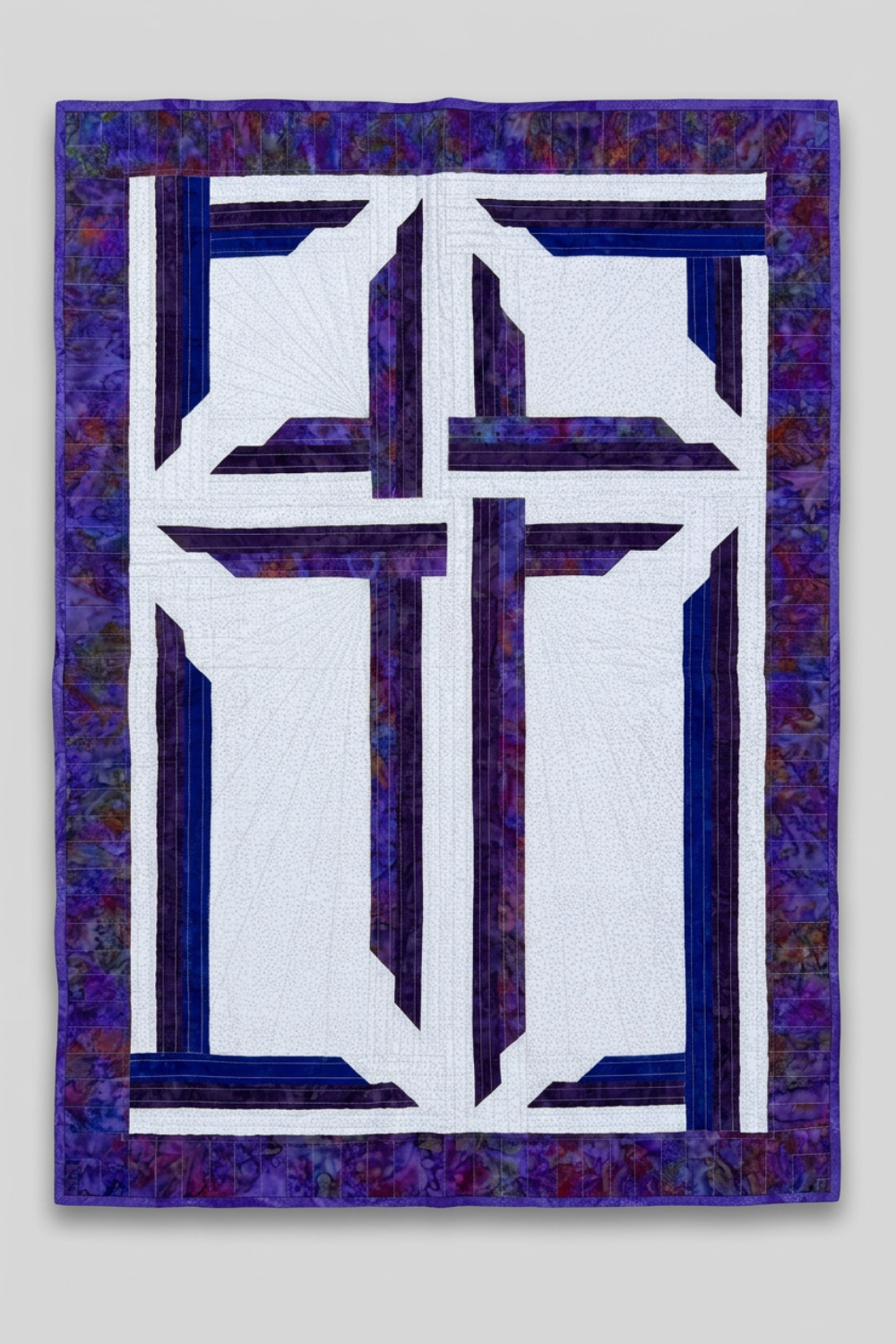 The Wondrous Cross handmade wall quilt with a purple cross, blue accents, a white patterned background, and a wide purple batik border against light grey.