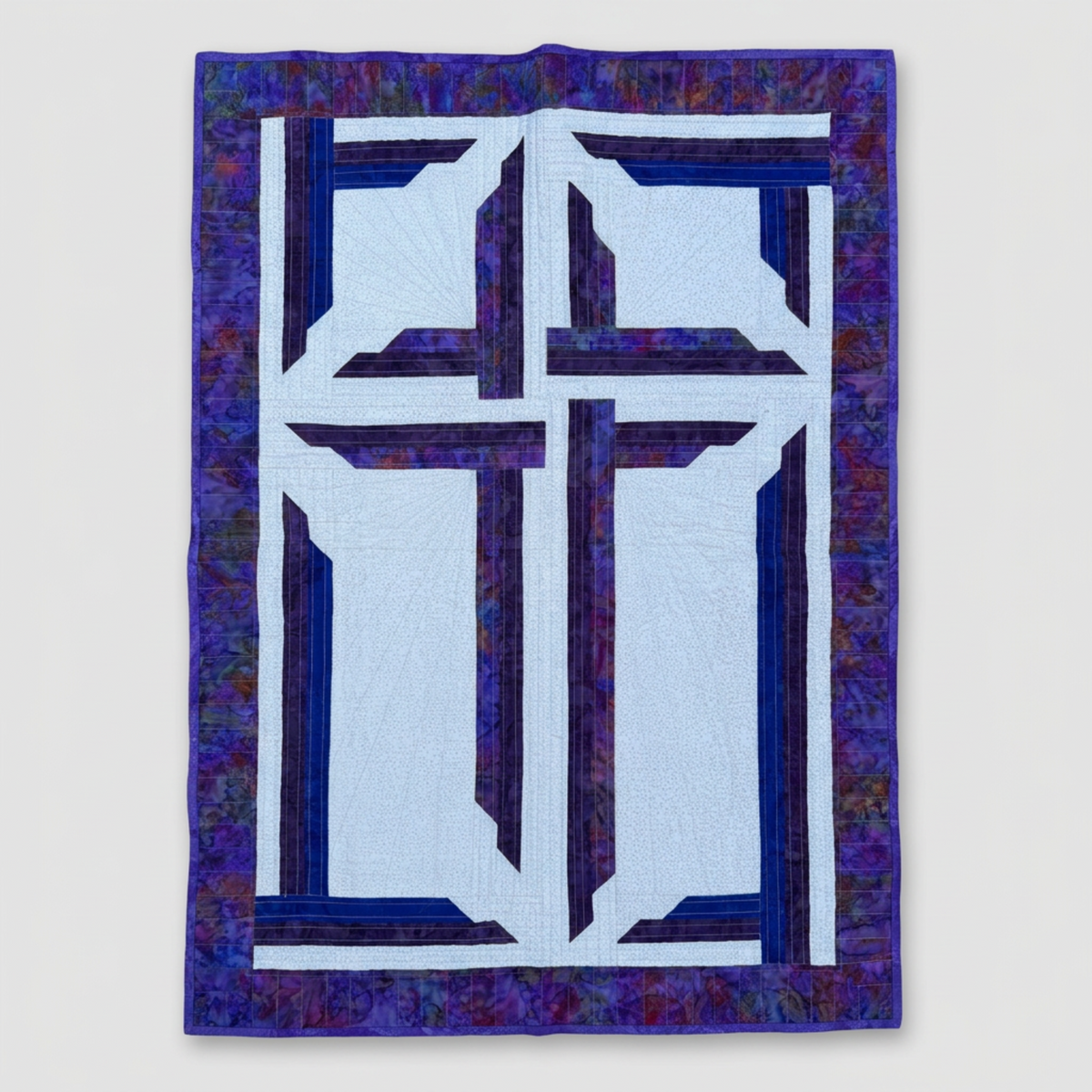 The Wondrous Cross handmade wall quilt with a purple cross, blue accents, a light patterned background, and a wide purple batik border against light grey.