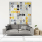 Writing on the Wall quilting cotton collection by FreeSpirit Fabrics -- featured in a modern flying geese wall quilt with black word collage, white word collage, and golden yellow abstract scratch print fabrics scattered as geese blocks on a white background, displayed in a minimal contemporary living room