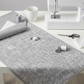 Writing on the Wall Well Worded White quilting cotton by FreeSpirit Fabrics -- styled modern sewing room flat lay in bright minimal aesthetic with grey and white word collage fabric, modern sewing machine, thread spools, scissors, and coordinating grey and white swatches