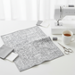 Writing on the Wall Well Worded White quilting cotton by FreeSpirit Fabrics -- styled modern sewing room flat lay with grey and white word collage fabric alongside sleek sewing machine, grey and white thread spools, scissors, and coordinating grey and white fabric swatches