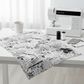 Writing on the Wall Word Collage White quilting cotton by FreeSpirit Fabrics — styled modern sewing room flat lay with bold black and white word collage fabric alongside sleek sewing machine, black and white thread spools, scissors, and coordinating black and white fabric swatches